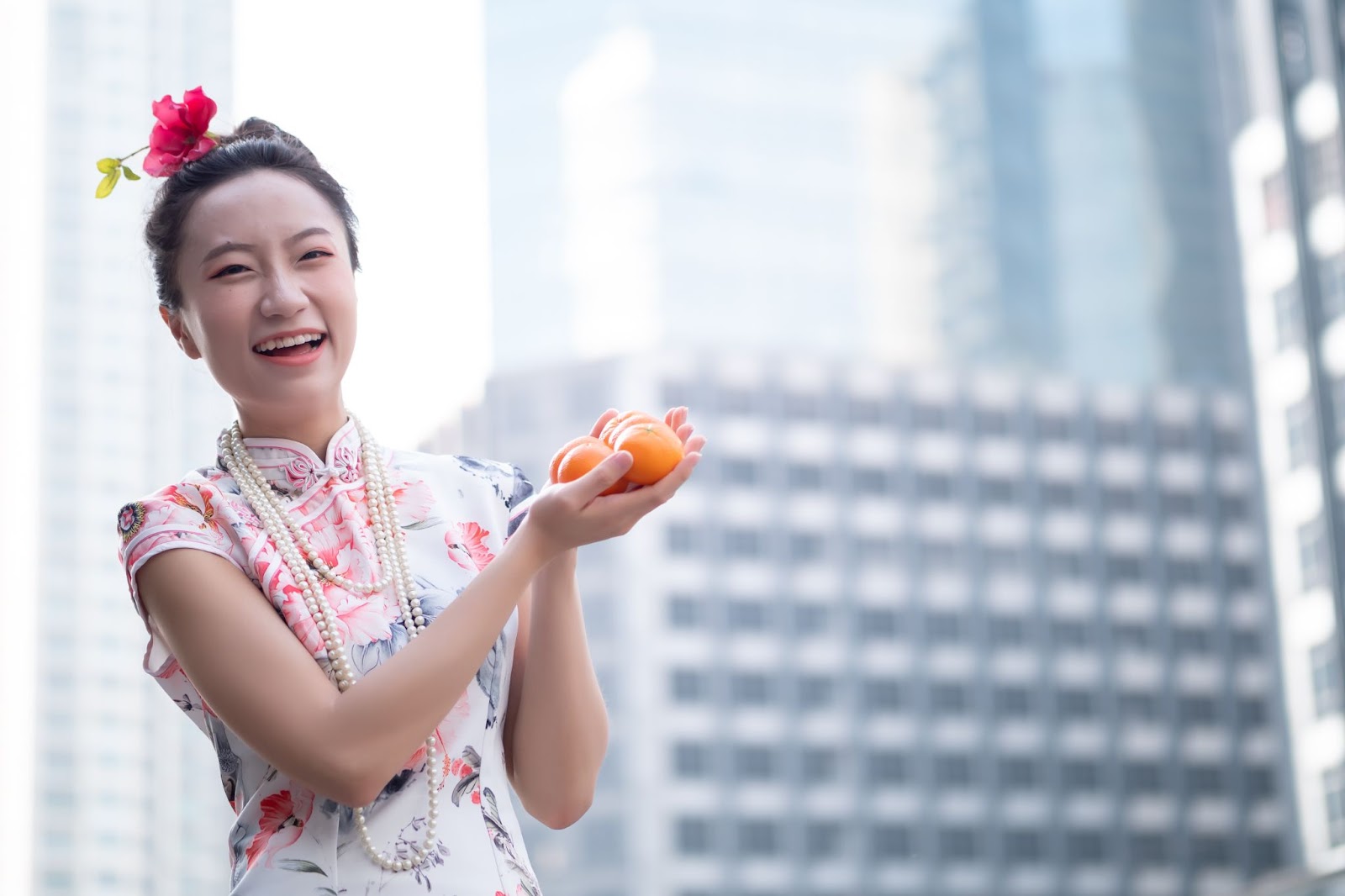 girl in qi pao holding mandarin